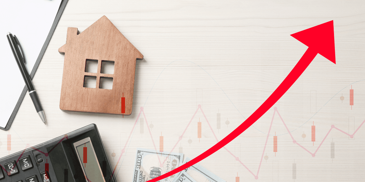 Wooden house model, calculator, money, and an upward trend graph on a desk