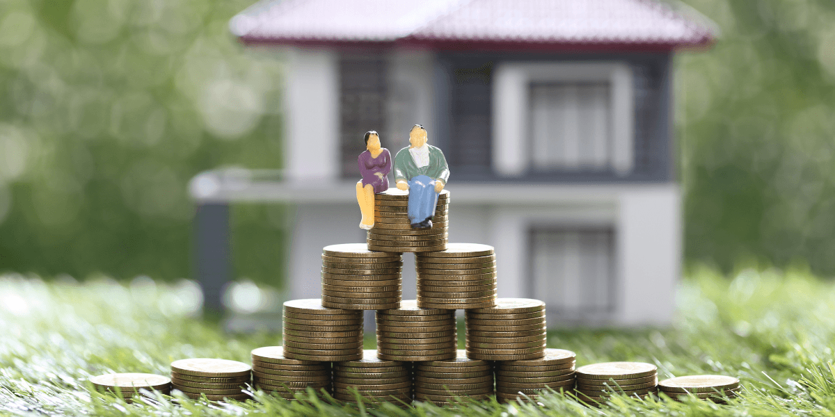 Miniature figures sit on stacks of coins in front of a house model