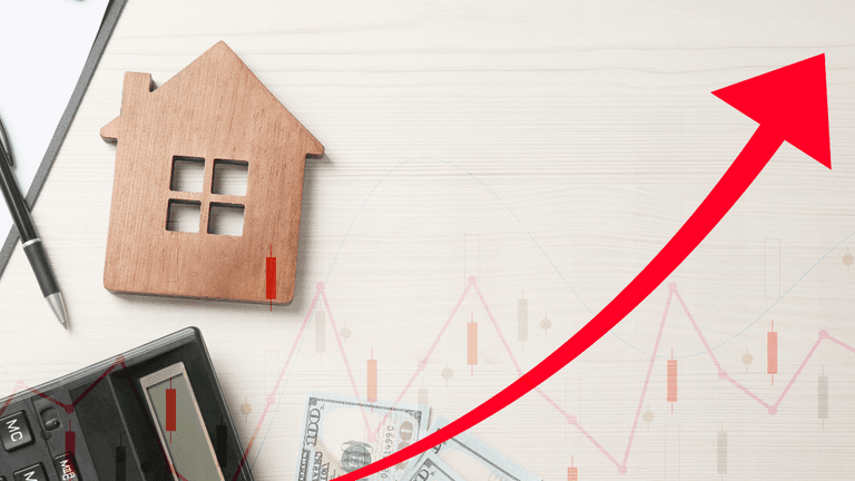 Wooden house model, calculator, money, and an upward trend graph on a desk