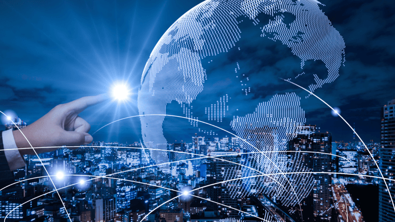 A hand reaches toward a digital globe over a city skyline with network lines.